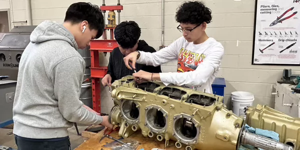 students working on airplane part