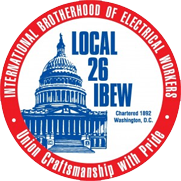Badge of the Local 26 International Brotherhood of Electrical Workers. A red ring around ablue building. 